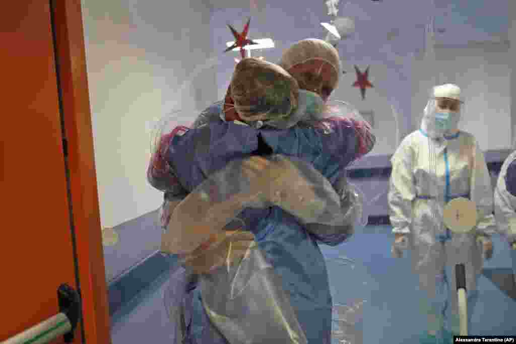 Італійка Ела Губбіотті обіймає свого партнера анестезіолога Джанкарло Ваннімартіні, який впродовж 10 днів перебував у шпиталі, у спеціально обладнаній палаті, де пацієнти та родичі можуть обіймати один одного захищені лише пластиковою плівкою. COVID-лікарня Ospedale dei Castelli в Ариччі, поблизу Риму, Італія, 20 січня 2021 року
