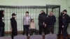 De la stânga la dreapta: Dmitri Popov, Artiom Sakov, Uladzimir Țihanovici, Ihar Losik, Serghei Țihanovski și Mikalai Statkevici în cușca inculpaților în timpul ședinței de judecată unde au fost condamnați de instanța din Gomel pe 14 decembrie.