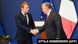 French President Emmanuel Macron (left) shakes hands with Hungarian Prime Minister Viktor Orban after addressing a joint press conference in Budapest in December 2021. 