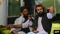 Taliban fighters pose for a selfie with a mobile phone in Kabul.