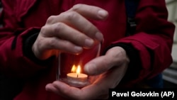 A demonstrator holds a candle as people gather in front of the Supreme Court in Moscow on December 14.