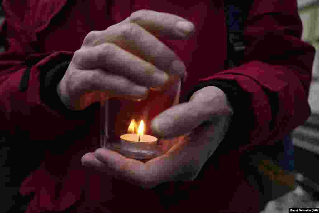 A demonstrator holds a candle as people gather in front of Russia&#39;s Supreme Court in Moscow on December 14. The Supreme Court has resumed a hearing into a request by federal prosecutors to shut down one of the post-Soviet world&#39;s oldest and most prestigious human rights organizations, Memorial International.