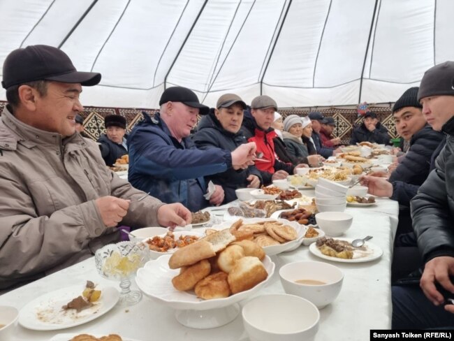 Люди собрались за столом, чтобы почтить память жертв Жанаозенских событий. Жанаозен, 11 декабря 2021 года