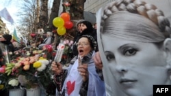 A supporter of Yulia Tymoshenko holds her portrait during a rally in front of the Kyiv 's prison as they mark her 51st birthday 