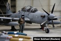 An Afghan pilot stands next to A-29 Super Tucano during a handover ceremony from U.S. to Afghan forces in Kabul on September 17, 2020.