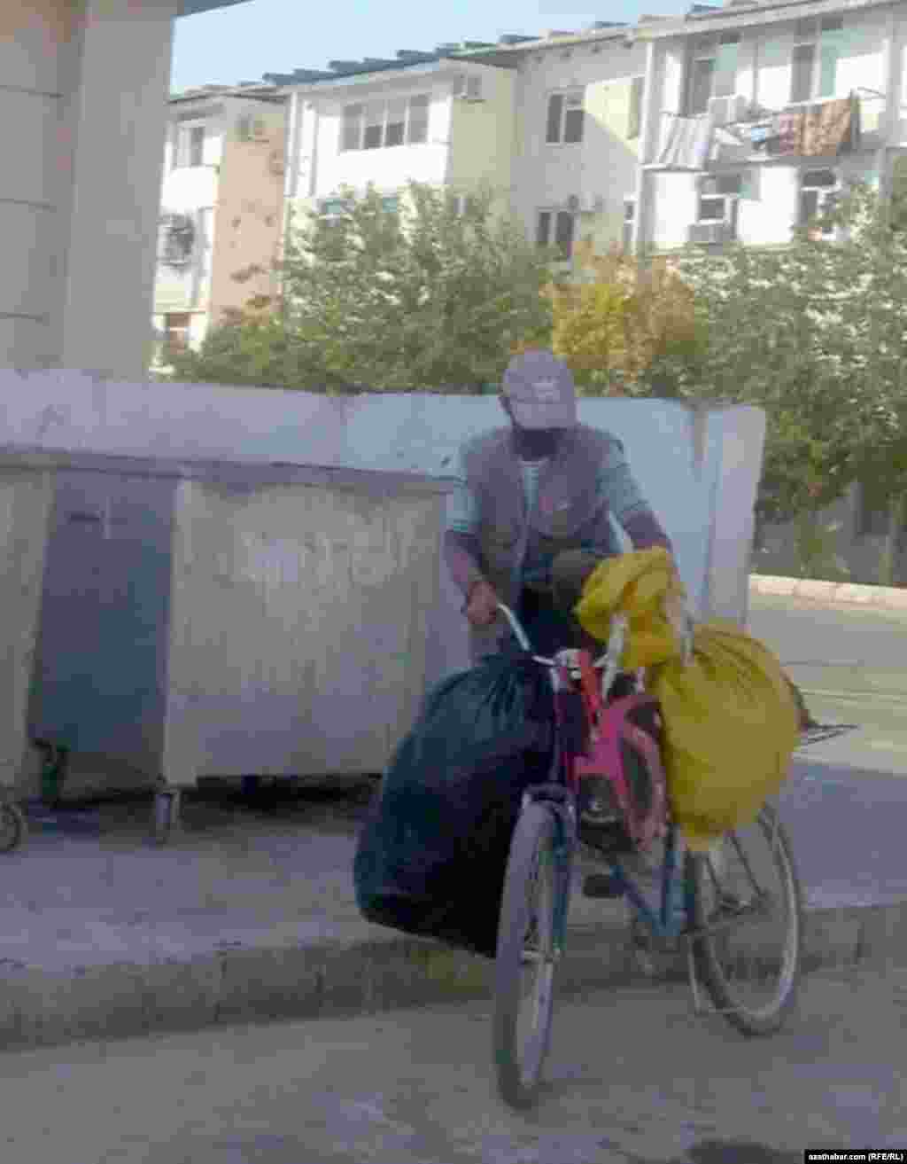 Tigir ýüküni tutan adam. Ykdysady kynçylyk mätäçleri barha kän zibil çeleklerine tarap kowýar. Aşgabat, 2021.&nbsp;