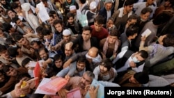 Afghans gathered outside the passport office in Kabul in October after Taliban officials announced they would start issuing passports following months of delays. The office was shut down again days later after biometric equipment broke down.