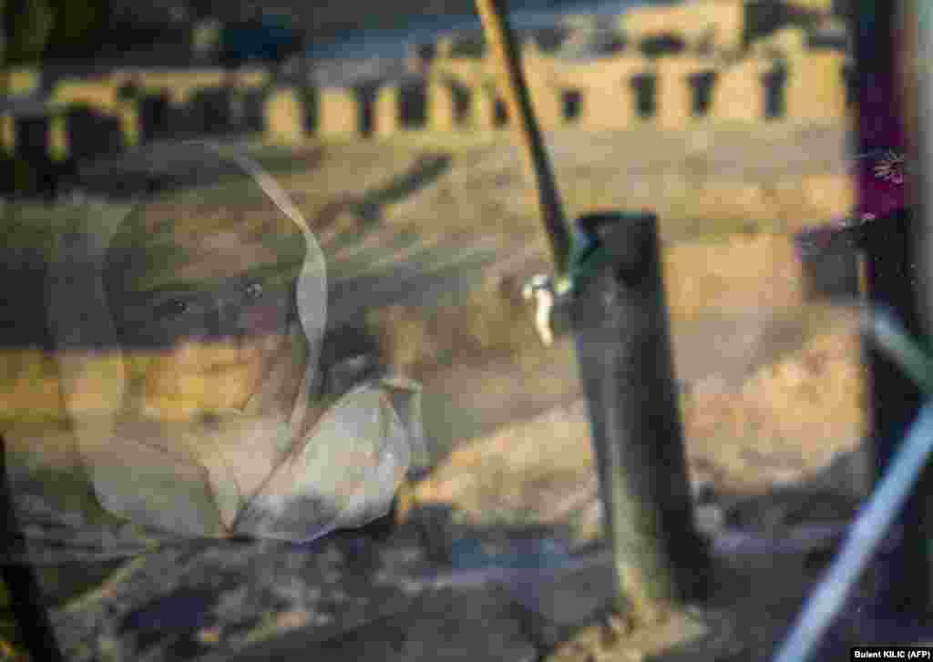 Sziklába vájt barlangjának ablakán kinéz egy kislány Bámijánban október 3-án