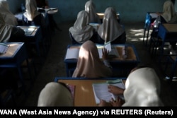 Afghan girls sit in a classroom in Kabul on September 18.