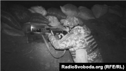 Військовослужбовець ЗСУ веде вогонь у відповідь на обстріл бойовиків