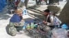 Sayed Abdul Rahman (right) hasn't been paid his teacher's salary for so long that he now repairs broken watches to try to feed his family. (video grab)