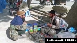 Sayed Abdul Rahman (right) hasn't been paid his teacher's salary for so long that he now repairs broken watches to try to feed his family. (video grab)