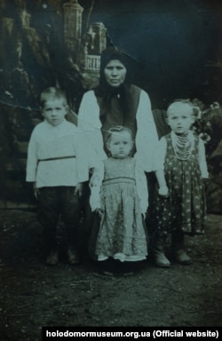 Фото сім'ї Клименків: мати і троє дітей, (бл. 1931 року) Крайній ліворуч Клименко Володимир Григорович, майбутній чоловік свідка Голодомору Клименко Парасковії.