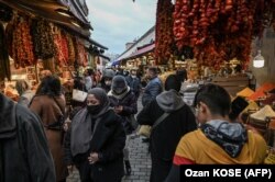Люди рядом с магазинами специй в районе Эминёню в Стамбуле. 24 ноября 2021 года. В этот день турецкая лира упала до рекордно низкого уровня после того, как президент Реджеп Тайип Эрдоган продолжил снижение процентных ставок