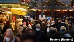 Maszkot viselő járókelők a frankfurti karácsonyi vásáron 2021. november 22-én