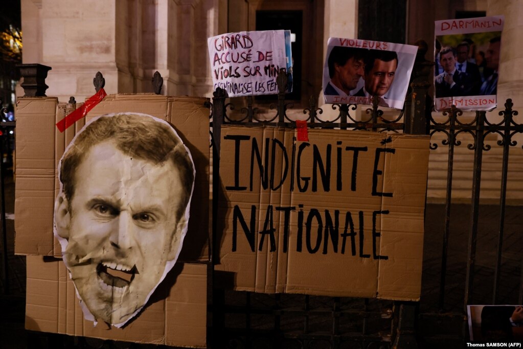 Një banderolë me mbishkrimin "Poshtërim kombëtar" shihet pranë një portreti të presidentit francez, Emmanuel Macron, gjatë një demonstrate, në Paris, Francë.