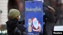На коледен базар в Германия Дядо Коледа е изобразен с предпазна маска.