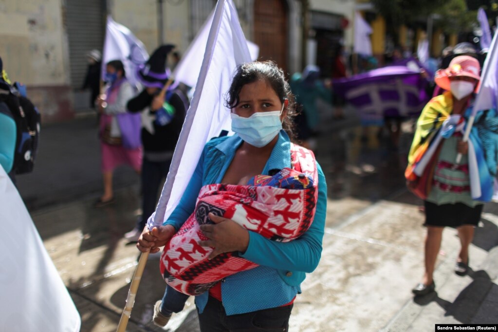 Një grua, me beben e saj, duke marrë pjesë në një protestë, në Guatemala Siti, Guatemalë.