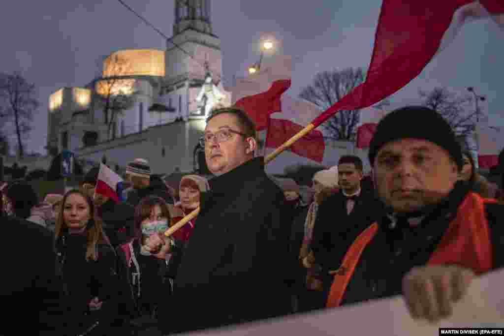 People take part in a demonstration supporting soldiers, police officers, and territorial defense forces at the Polish-Belarusian border in Bialystok in eastern Poland on November 21. Dozens of people waving Polish national flags and banners attended.