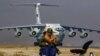 A Taliban fighter sits guard against the backdrop of a Russian plane transporting aid relief donated by Russia at&nbsp;Kabul International Airport.