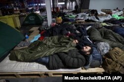 Migranți într-un centru logistic la punctul de control Kuznița, la granița dintre Belarus și Polonia, lângă Hrodna - 21 noiembrie 2021.