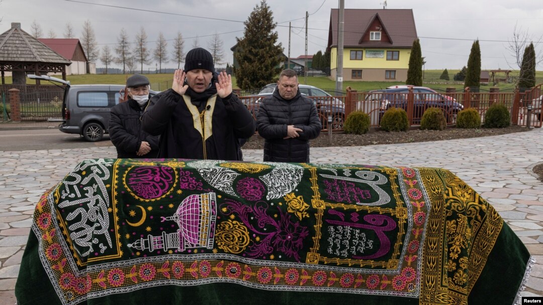 Membri ai comunității tătare participă la înmormântarea unui migrant african fără nume, victimă a crizei migranților de la granița Poloniei cu Belarus, în satul Bohoniki, Polonia, 18 noiembrie 2021.