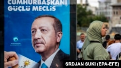 Женщина рядом с агитационным постером действующего президента и кандидата в президенты Турции Реджепа Тайипа Эрдогана. Стамбул, 18 июня 2018 года.