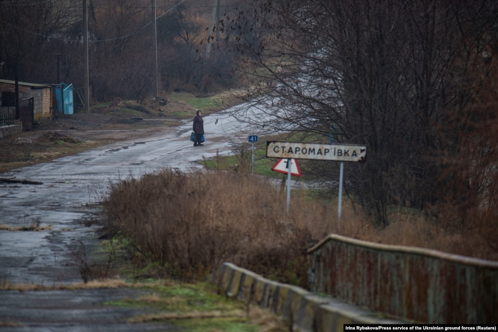 Një grua, duke qëndruar në një rrugë, në fshatin Staromarivka, që ndodhet në vijën ndarëse të Ukrainës, ndërmjet territorit të kontrolluar nga qeveria dhe enklavës së kontrolluar nga forcat separatiste të mbështetura nga Rusia, në rajonin e Donetskut, në Ukrainë. (23 nëntor)