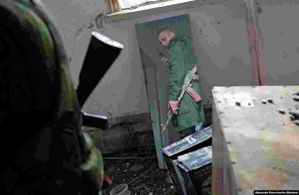 Një militant i të vetëquajturës Republikë Popullore e Luhanskut duket në pasqyrë, në pozicionet e luftimit, në vijën e ndarjes nga forcat e armatosura ukrainase, në rajonin e Luhanskut, në Ukrainë. (21 prill)