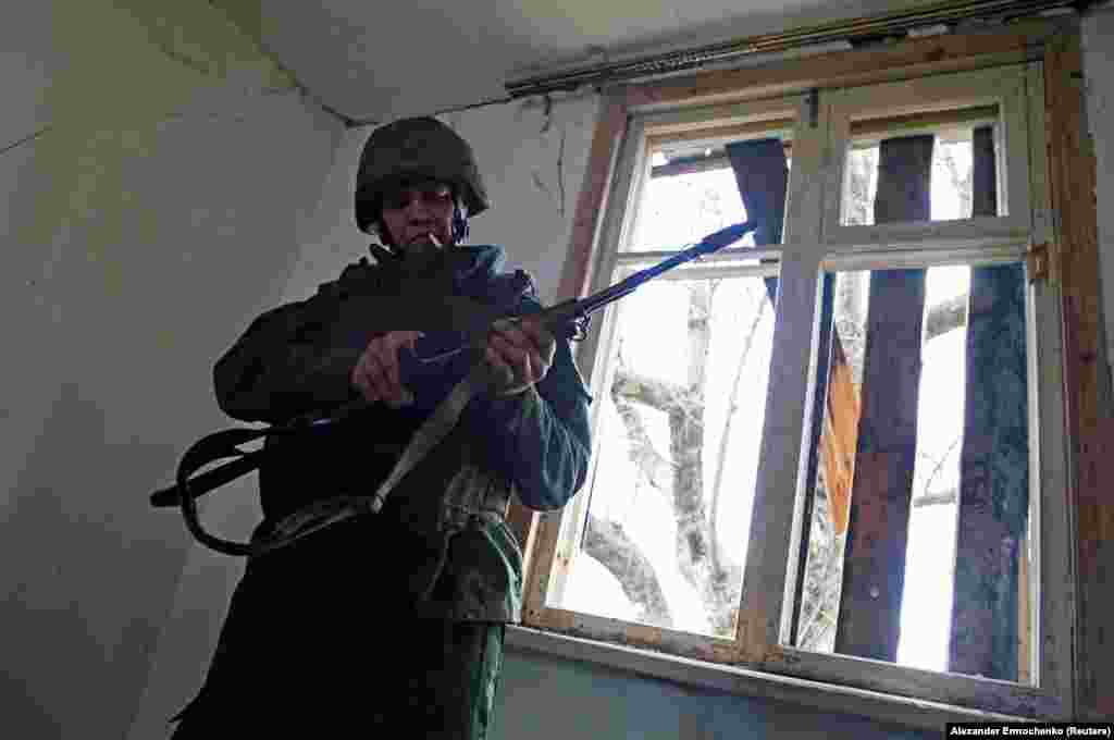 Një militant i të vetëquajturës Republikë Popullore e Luhanskut, duke mbajtur pushkën e tij, në pozicionet e luftimit, në vijën e ndarjes nga forcat e armatosura ukrainase, në rajonin e Luhanskut, në Ukrainë. (21 prill)