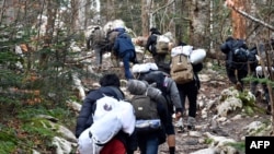 Migranti hodaju šumskom stazom prema hrvatskoj granici, nakon što su 8. decembra 2019. napustili improvizovani kamp "Vučjak", na periferiji sjevernobosanskog grada Bihaća, u još jednom pokušaju ilegalnog prelaska u EU.