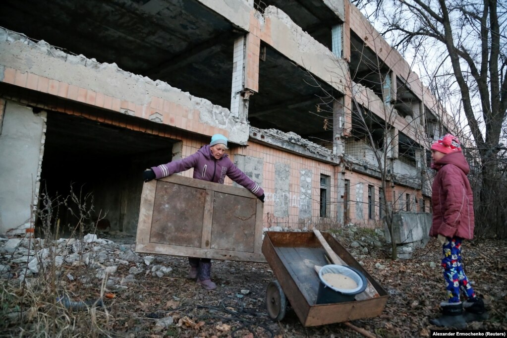 Angelica, 49-vjeçare, dhe e bija e saj, Anastasiya, 13-vjeçare, duke mbledhur pjesë mobiliesh, për t'i djegur për ngrohje, pranë një ndërtese të braktisur të një miniere qymyri, në qytetin e Horlivkës, që kontrollohet nga rebelët, pranë Donetskut, në Ukrainë. (24 nëntor)