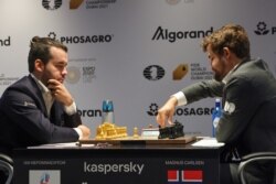 Jan Nyepomnyascsij orosz sakkozó (b) norvég ellenfelével, Magnus Carlsennel játszik a sakkvilágbajnokságon Dubajban 2021. december 1-jén