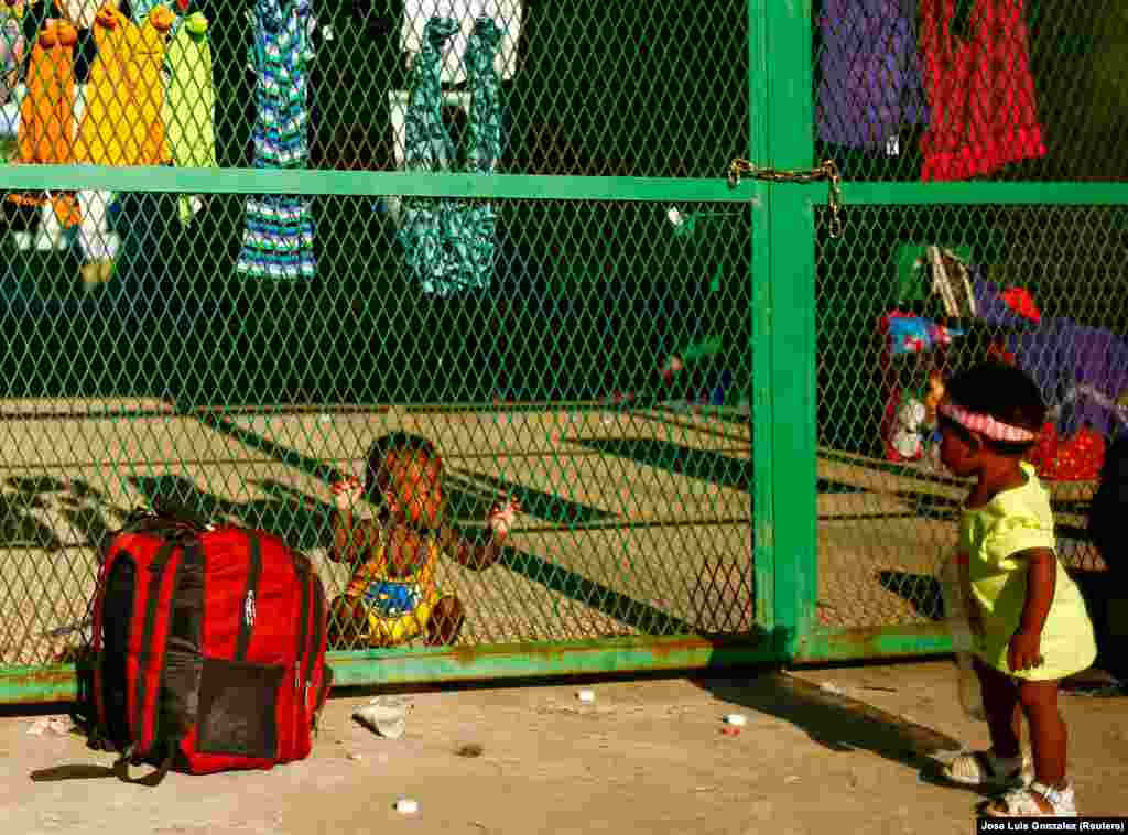 Gyerekek nézik egymást a kerítésen át a mexikói Tapachula városában 2021. december 2-án, miközben menekült szüleik arra várnak, hogy humanitárius vízumot kapjanak a mexikói kormánytól, és átjuthassanak a határon
