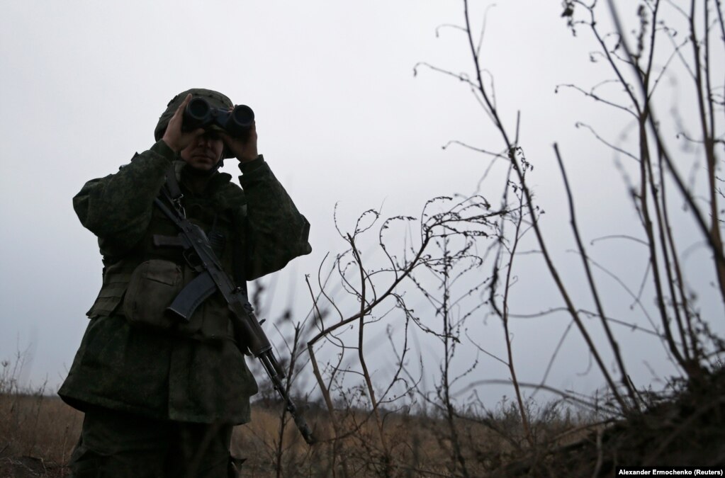 Një militant i të vetëquajturës Republikë Popullore e Luhanskut, duke shikuar me dylbi, teksa bënte rojë, në pozicionet e luftimit, në vijën e ndarjes nga forcat e armatosura ukrainase, në periferi të Kirovskut, në rajonin e Luhanskut, në Ukrainë. (1 dhjetor)