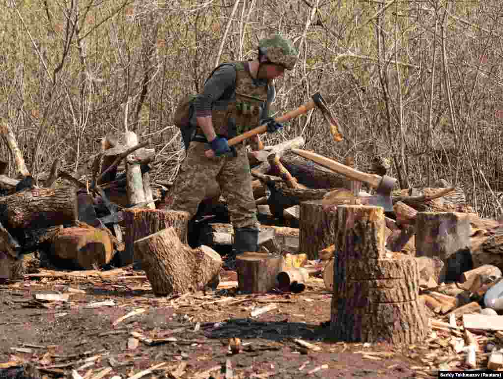 Një pjesëtar i forcave të armatosura ukrainase, duke prerë drunj, në pozicionet e luftimet, në vijën e ndarjes, pranë qytetit të Donetskut, që kontrollohet nga rebelët, në Ukrainë. (21 prill)