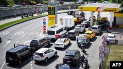 Люди выстраиваются в очередь, чтобы заправить свои автомобили на автозаправочной станции «Роснефть» в Москве, 30 июня 2026 года