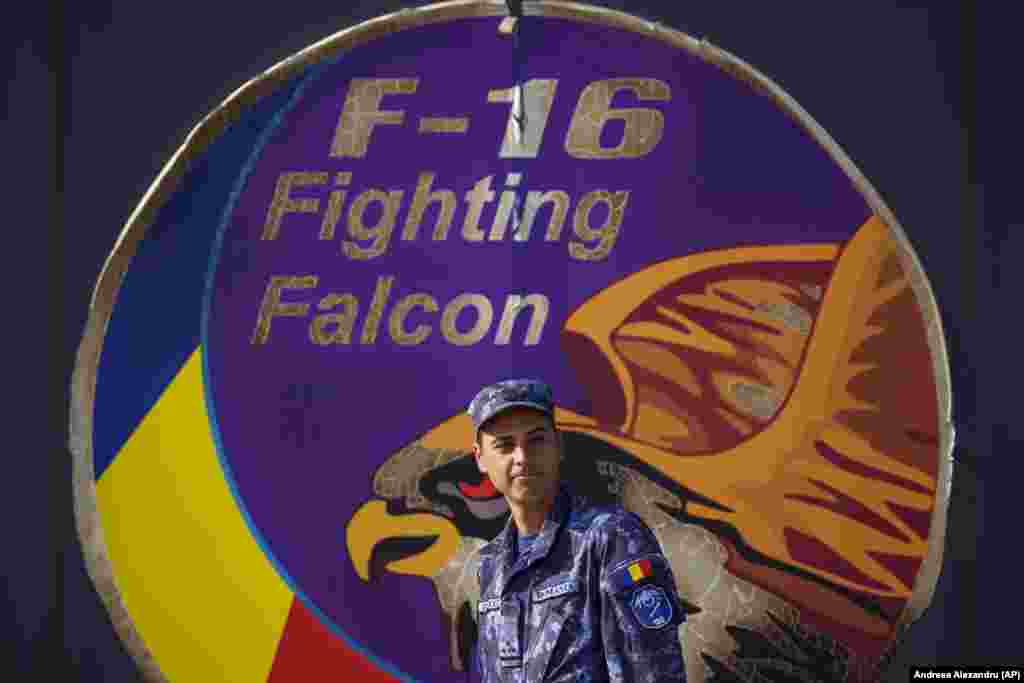 A Romanian serviceman walks by a logo on a hangar door at the air base. In August, the United States approved sending F-16 fighter jets to Ukraine from Denmark and the Netherlands as soon as pilot training was completed.&nbsp;