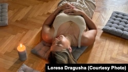 Loresa Dragusha, duke medituar në apartamentin e saj në Prishtinë.