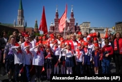 Russian children celebrate their enrollment in the Communist Party's Pioneer youth organization by posing on Red Square on May 19.