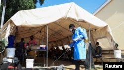 Zdravstveni radnik dezinfikuje šator protiv kolere u poliklinici Kuvadžana u Harareu, Zimbabve, 24. novembra 2023.