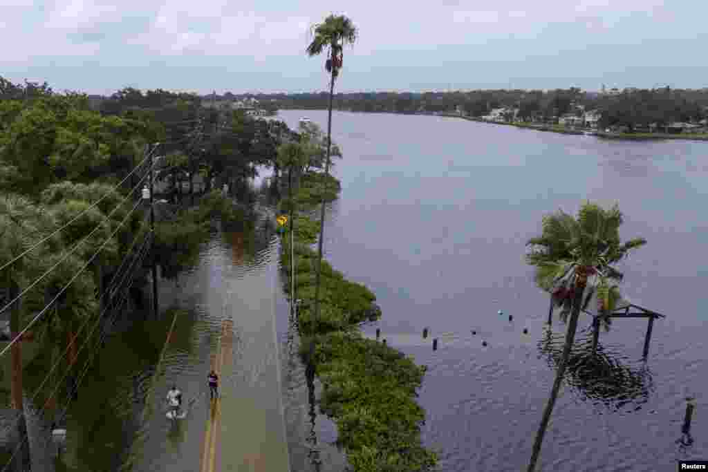 Banorët duke ecur nëpër një rrugë të përmbytur në Tarpon Springs, Florida.