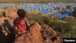 Дете седи на врвот на ридот со поглед кон бегалски камп во близина на границата Чад-Судан, 9 ноември, 2023 година.
