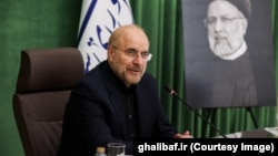 Mohammad Baqer Qalibaf cu portretul ayatollahului Ali Khamenei în fundal, la parlamentul iranian, în vara anului 2024.