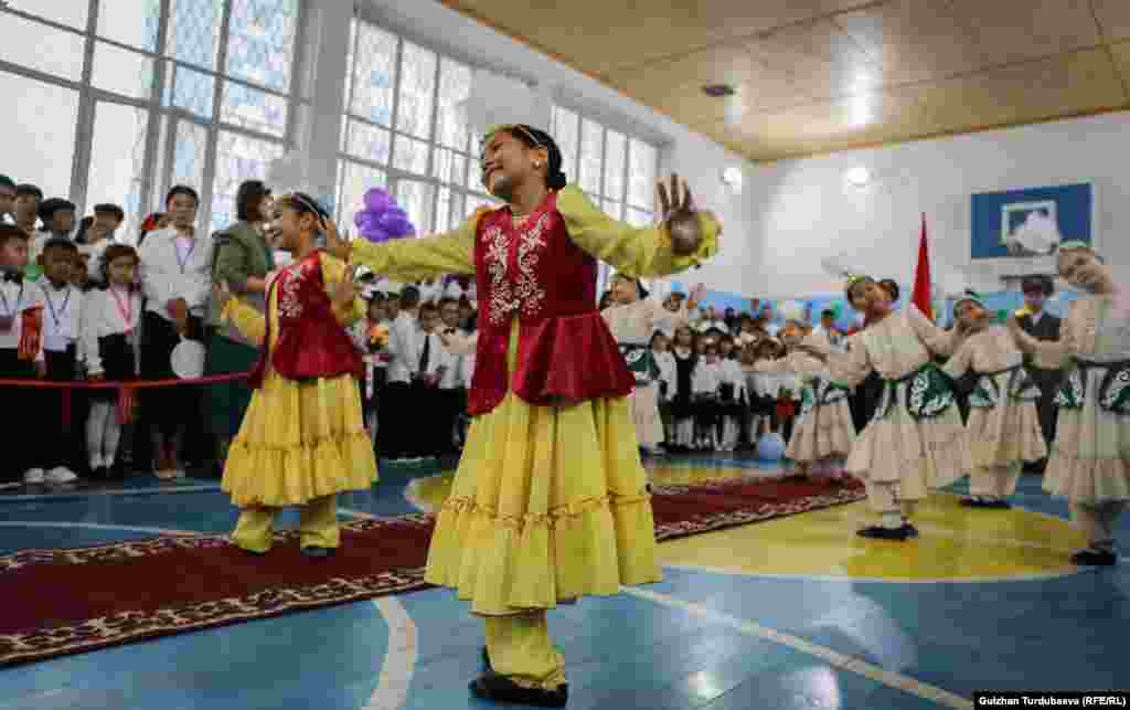 Children watch as traditional songs and dances are performed, welcoming them to the new school year in Bishkek.