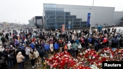 Люди у стихийного мемориала погибшим в атаке на «Крокус Сити Холл»
