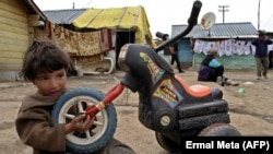 A Romany boy plays with his plastic tricycle in the Zitkovac camp in March 2005.