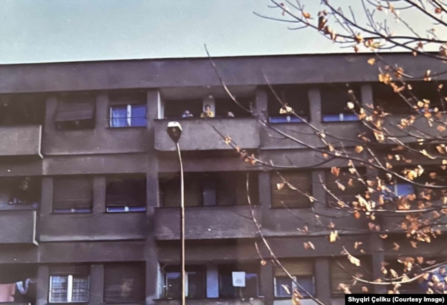 Banesa e Shyqri Çelikut në Mitrovicën e Veriut e fotografuar në vitet '90. Në ballkon shihen prindërit dhe vëllai i Shyqriut.