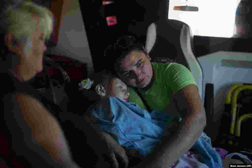 Viktoria Chumak holds her 4-year-old daughter, Lilia, inside an ambulance operated by volunteers in Kupyansk, in eastern Ukraine, on August 14. Settlements near Kupyansk are being evacuated once again as Russian forces intensify their efforts to break through the Ukrainian front lines east of the Oskil River. &nbsp;