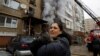 A woman holds her cat, which was carried by a firefighter out of an apartment building damaged by Russian shelling in Donetsk, Russian-controlled Ukraine, on December 19.